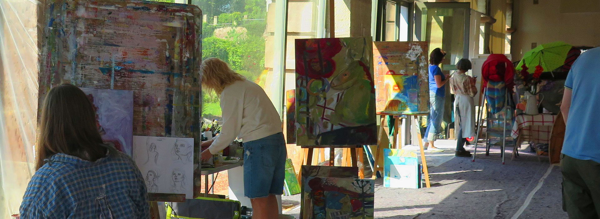 Frauen malen in einem Atelier in das die Sonne scheint abstrakte Bilder